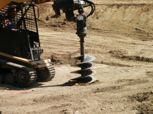 Heavy machinery drilling into ground Auger attachment
