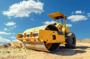 Yellow compactor roller on construction site