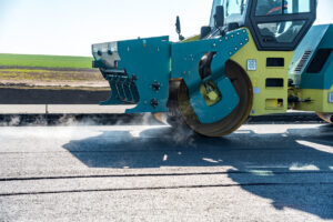 Heavy machinery paving a road surface.