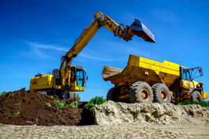Excavator loading dirt into dump truck.