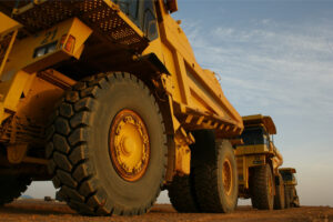 Large yellow dump trucks on dirt terrain