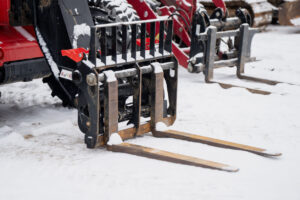 Snow-covered skid steer pallet forks