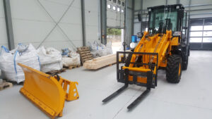 Skid steer with attachments in warehouse