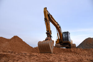 Yellow Crawler Excavator in red cay mud
