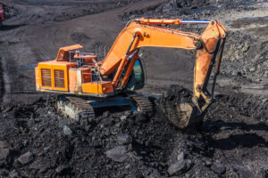 Orange excavator digging in dirt