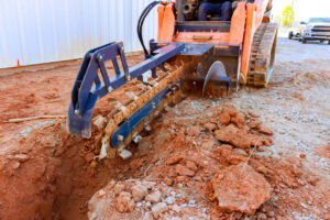 Trencher digging into the ground.