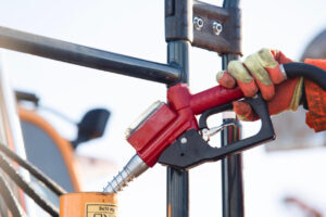 Refueling an excavator with gasoline.