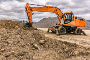 orange wheeled excavator in brown dirt and rocks