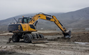 yellow wheeled excavator in fog